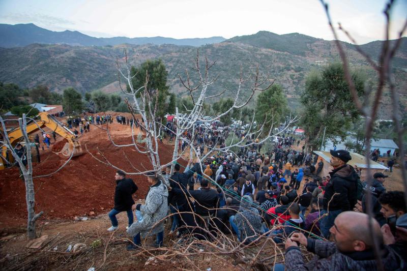 Bystanders watch as Moroccan authorities and firefighters work to rescue five-year-old boy Rayan, who is trapped in a deep well for over two days, near Bab Berred in Morocco's rural northern province of Chefchaouen on February 3, 2022. - Moroccans waited anxiously as authorities said a dramatic operation to rescue a young boy trapped in a deep well for more than 40 hours was nearing its end. (Photo by AFP)