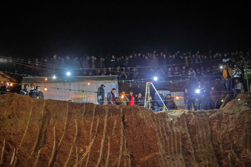 Bystanders watch as Moroccan authorities and firefighters work to rescue five-year-old boy Rayan, who is trapped in a deep well for over two days, near Bab Berred in Morocco's rural northern province of Chefchaouen on February 3, 2022. - Moroccans waited anxiously as authorities said a dramatic operation to rescue a young boy trapped in a deep well for more than 40 hours was nearing its end. (Photo by AFP)