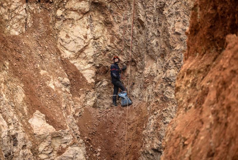 A Moroccan emergency services climber works on the rescue of five-year-old boy Rayan from a well shaft he fell into on February 1, in the remote village of Ighrane in the rural northern province of Chefchaouen on February 4, 2022. - Moroccan rescuers were in the nerve-wracking final stages of a marathon effort to rescue Rayan, a five-year-old boy trapped down a well for a fourth night. (Photo by Fadel SENNA / AFP)